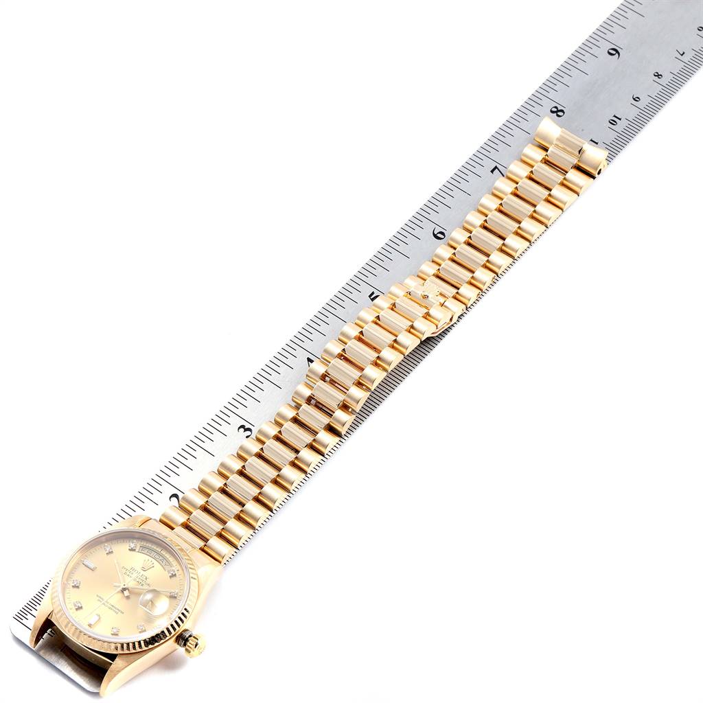 The Rolex President 18038 Men
s Yellow Gold Champagne Dial 18038 Men
s Yellow Gold Champagne Dial model watch is shown with its bracelet next to a ruler for measurement.