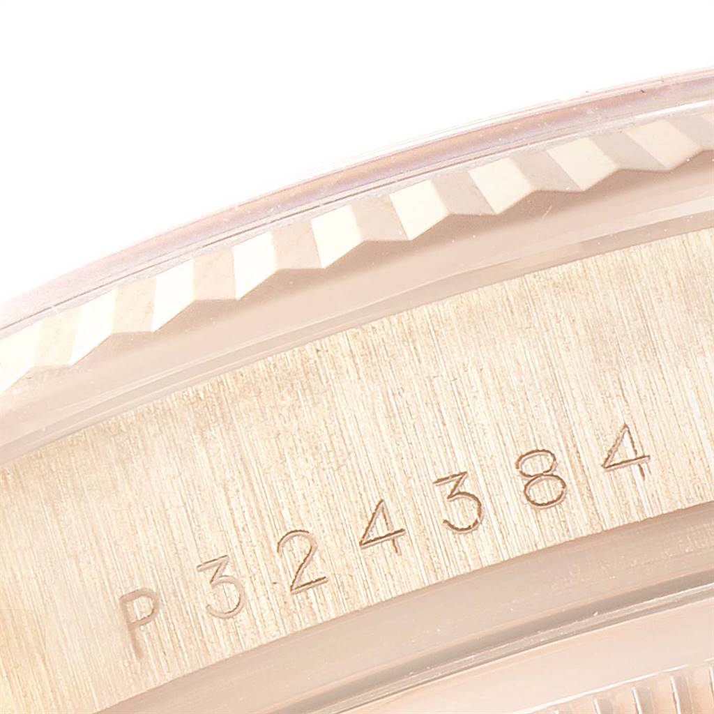 This close-up image shows the engraved serial number on the side of a Rolex President 118235 Men's Rose Gold Champagne Dial 118235 Men's Rose Gold Champagne Dial model watch bezel.