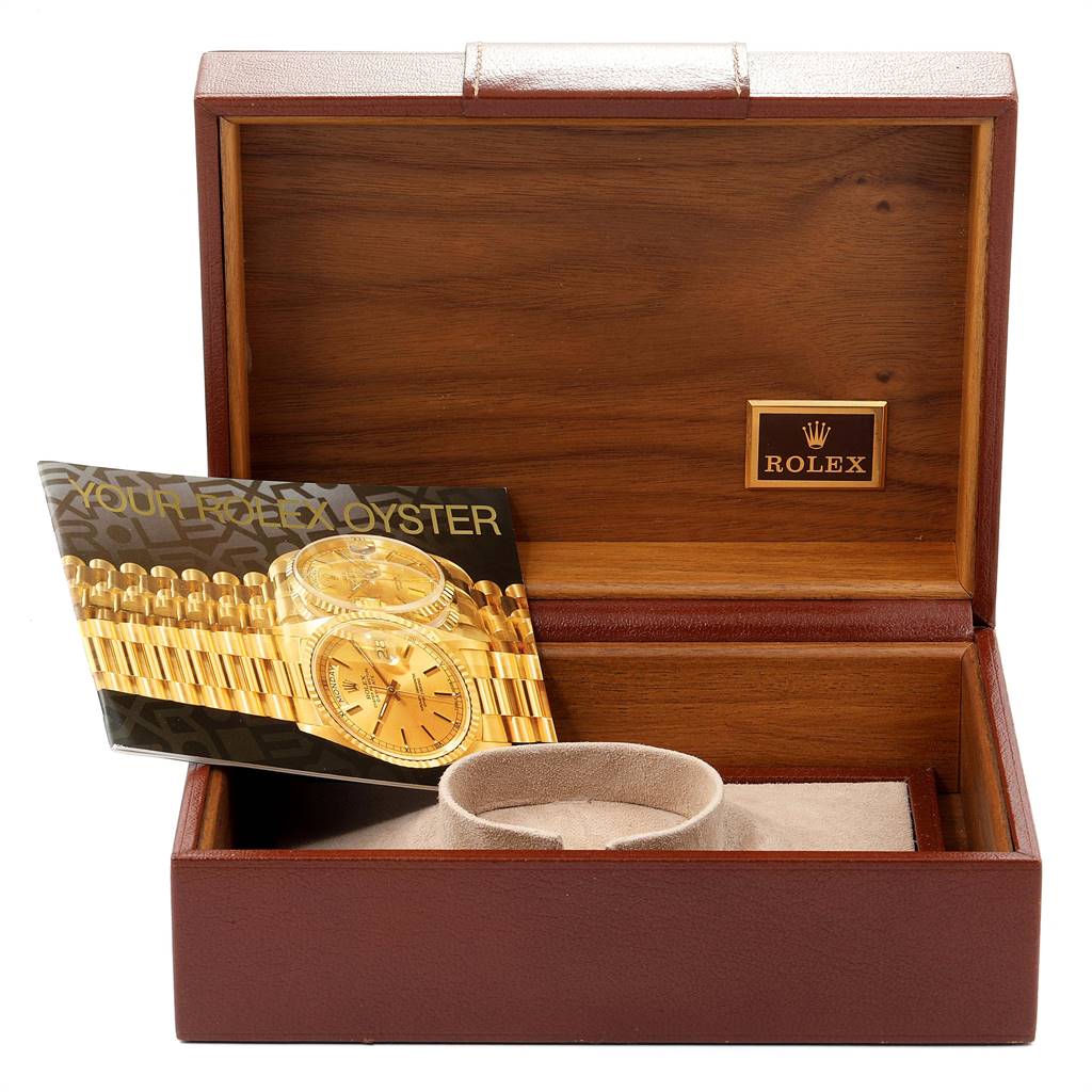 The image shows a Rolex President 19018 Men
s Yellow Gold Black Dial 19018 Men
s Yellow Gold Black Dial model watch box with a booklet and cushion inside.