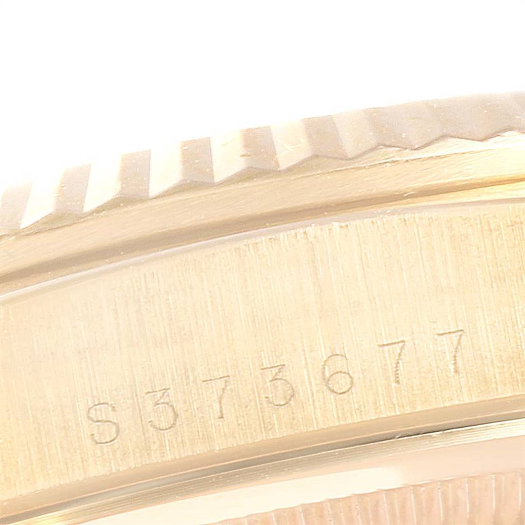 This close-up image shows the serial number and part of the fluted bezel of a Rolex President 18238 Men
s Yellow Gold Black Dial 18238 Men
s Yellow Gold Black Dial model watch.