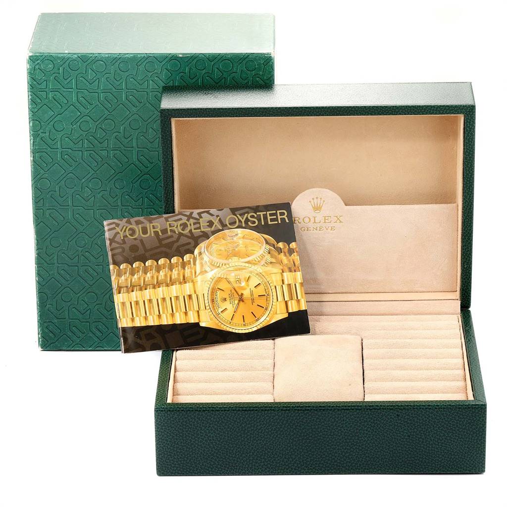 The image shows the packaging and a booklet of a Rolex President 18238 Men
s Yellow Gold Black Dial 18238 Men
s Yellow Gold Black Dial model watch, including an open green box with a beige interior.