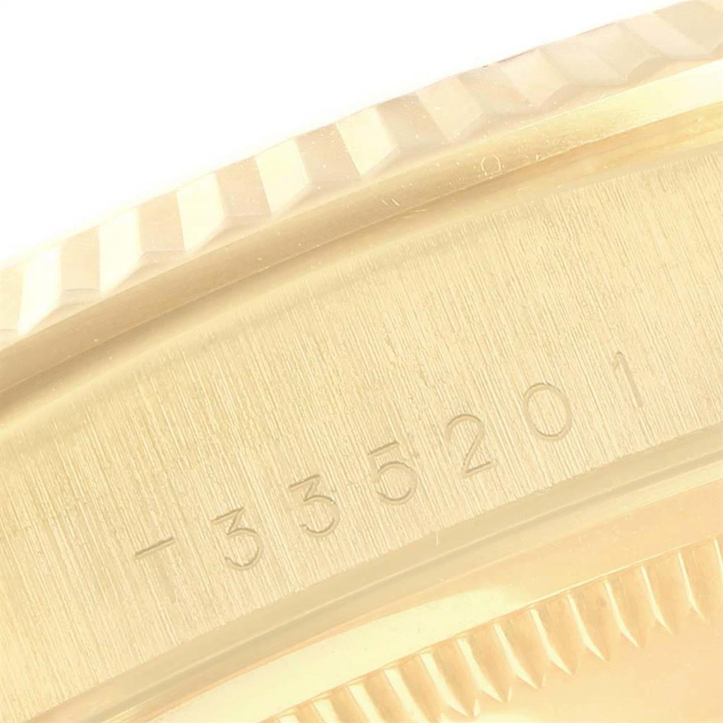 This image shows a close-up of the Rolex President 18238 Men
s Yellow Gold Beige Dial 18238 Men
s Yellow Gold Beige Dial model, highlighting the serial number and part of the fluted bezel.