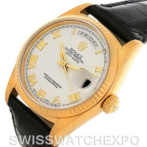 The image shows a Rolex President 18038 Men's Yellow Gold White Dial 18038 Men's Yellow Gold White Dial model watch with a gold case, white dial, Roman numerals, and a black leather strap at an angled view.