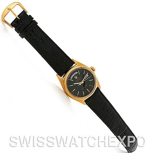 The image shows a top view of a Rolex President 1803 Men
s Yellow Gold Black Dial 1803 Men
s Yellow Gold Black Dial model watch with a black leather strap and gold case.