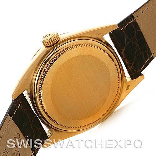 The image shows the back case, crown, and part of the leather strap of a Rolex President 1803 Men's Yellow Gold Champagne Dial 1803 Men's Yellow Gold Champagne Dial model watch.