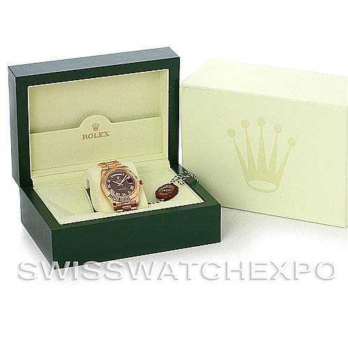 The image shows a Rolex President 218235RRP Men's Rose Gold Pink Dial 218235RRP Men's Rose Gold Pink Dial model watch angled inside its open Rolex box, alongside an outer box featuring the Rolex crown logo.