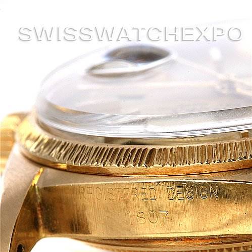 This image shows a close-up side angle of a Rolex President 1807 Men's Yellow Gold Champagne Dial 1807 Men's Yellow Gold Champagne Dial watch, highlighting its bezel and part of its case with engraved text.