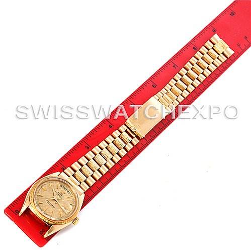 The image shows a top-down view of a Rolex President 1807 Men's Yellow Gold Champagne Dial 1807 Men's Yellow Gold Champagne Dial model watch laid next to a red ruler.