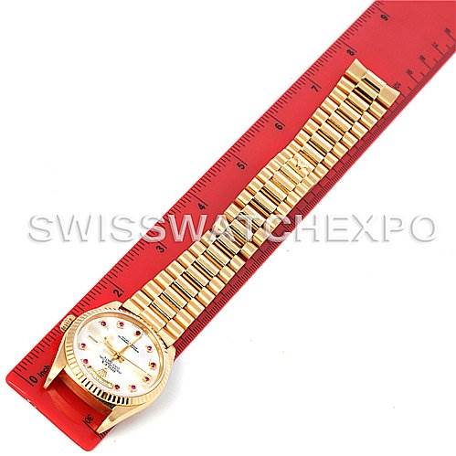 The image shows the Rolex President 18238 Men's Yellow Gold Mother of Pearl Dial 18238 Men's Yellow Gold Mother of Pearl Dial model watch, including the face and fully extended band, laying on a red ruler.
