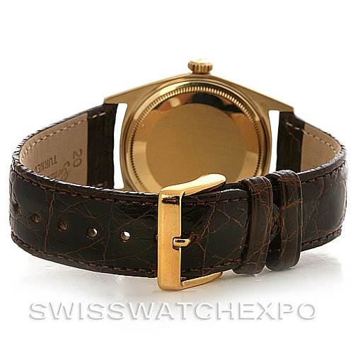 The image shows the back view of a Rolex President 1601 Men's Yellow Gold Champagne Dial 1601 Men's Yellow Gold Champagne Dial model with its gold case and brown leather strap.