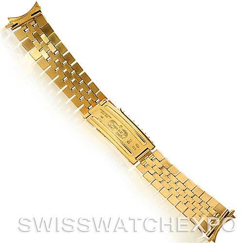 This image shows a Rolex President   model watch's gold bracelet and clasp from a top-down angle.