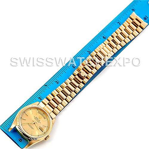 The image shows a Rolex President 18238 Men
s Yellow Gold Champagne Dial 18238 Men
s Yellow Gold Champagne Dial model watch laid flat alongside a blue measuring ruler.