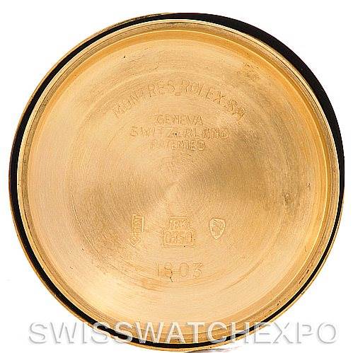 This is the inside case back of a President model Rolex watch in gold, showing engraved serial numbers and hallmarks.