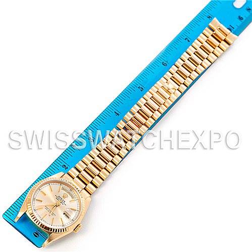This image shows a Rolex President 18238 Men
s Yellow Gold Champagne Dial 18238 Men
s Yellow Gold Champagne Dial model watch placed next to a blue ruler, featuring the watch case, dial, and bracelet.