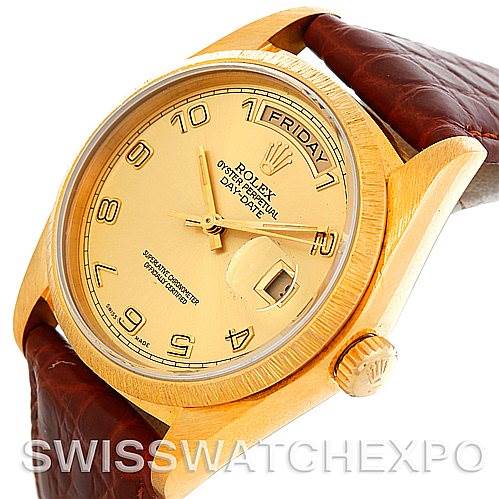 This image shows a close-up of the Rolex President 18078 Men's Yellow Gold Champagne Dial 18078 Men's Yellow Gold Champagne Dial watch face, crown, and part of the leather strap at an angled view.