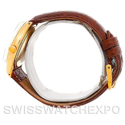 This image shows a side angle of the Rolex President 1005 Men's Yellow Gold Silver Dial 1005 Men's Yellow Gold Silver Dial watch focusing on the crown, case, and leather strap.