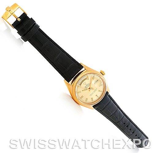 This image shows a Rolex President 1803 Men's Yellow Gold Champagne Dial 1803 Men's Yellow Gold Champagne Dial model watch laid flat, showcasing its black leather strap, gold case, and dial.