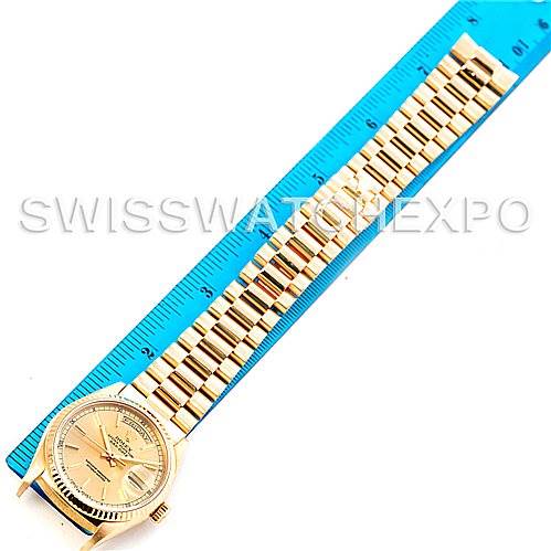 The Rolex President 18038 Men
s Yellow Gold Champagne Dial 18038 Men
s Yellow Gold Champagne Dial model watch is shown lying flat, displaying the face and full bracelet alongside a blue measuring ruler.