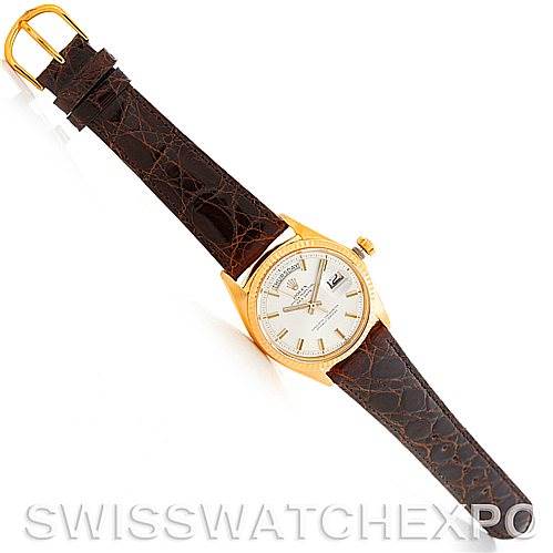 The Rolex President 1803 Men's Yellow Gold Silver Dial 1803 Men's Yellow Gold Silver Dial watch is shown from an aerial view, displaying its face, dial, and brown leather strap.