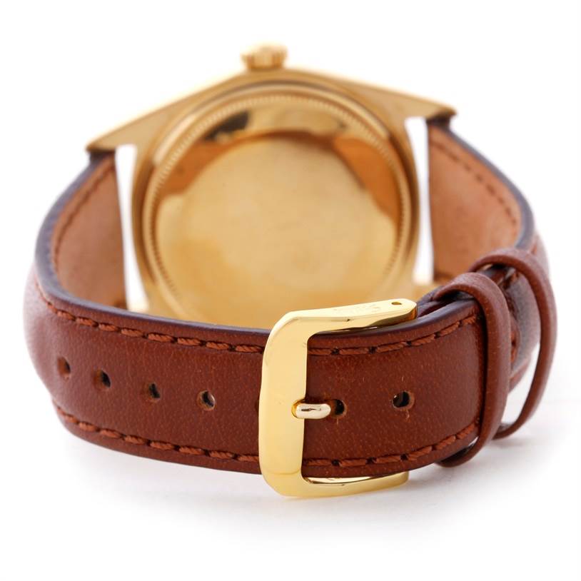 The image shows the back of a Rolex President 1803 Men
s Yellow Gold Champagne Dial 1803 Men
s Yellow Gold Champagne Dial model watch with a brown leather strap and gold buckle.