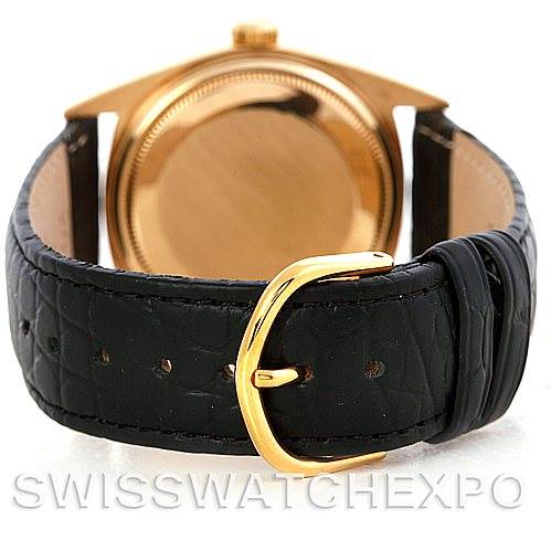 The image shows the back of a Rolex President 1803 Men
s Yellow Gold White Dial 1803 Men
s Yellow Gold White Dial model watch with a gold case and a black leather strap with a gold buckle.