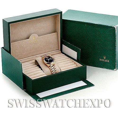 The image shows a Rolex President 18208 Men's Yellow Gold Black Dial 18208 Men's Yellow Gold Black Dial model watch placed inside its open green box with a beige interior.