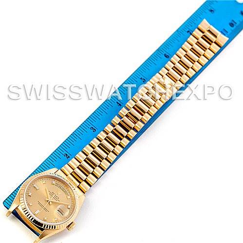 This image shows a Rolex President 18238 Men
s Yellow Gold Champagne Dial 18238 Men
s Yellow Gold Champagne Dial watch laid flat next to a blue measuring ruler, focusing on the watch face and bracelet.