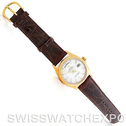 The image shows a top-down view of a Rolex President 1803 Men's Yellow Gold White Dial 1803 Men's Yellow Gold White Dial watch with a gold case and a brown leather strap.