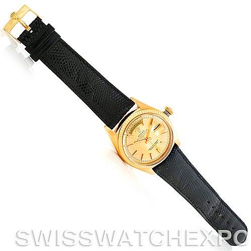 The image shows a Rolex President 1803 Men
s Yellow Gold Champagne Dial 1803 Men
s Yellow Gold Champagne Dial watch from a top-down angle, highlighting its gold case and black leather strap.