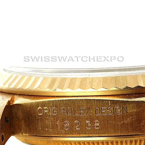 Side view of a Rolex President 18238 Men's Yellow Gold Beige Dial 18238 Men's Yellow Gold Beige Dial model showing the fluted bezel and part of the band with "ORIG ROLEX DESIGN" and model number engraved.