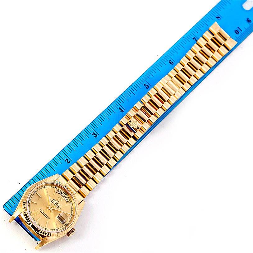 The image shows the Rolex President 18238 Men
s Yellow Gold Champagne Dial 18238 Men
s Yellow Gold Champagne Dial model watch laid flat next to a ruler, displaying the dial and the full bracelet.