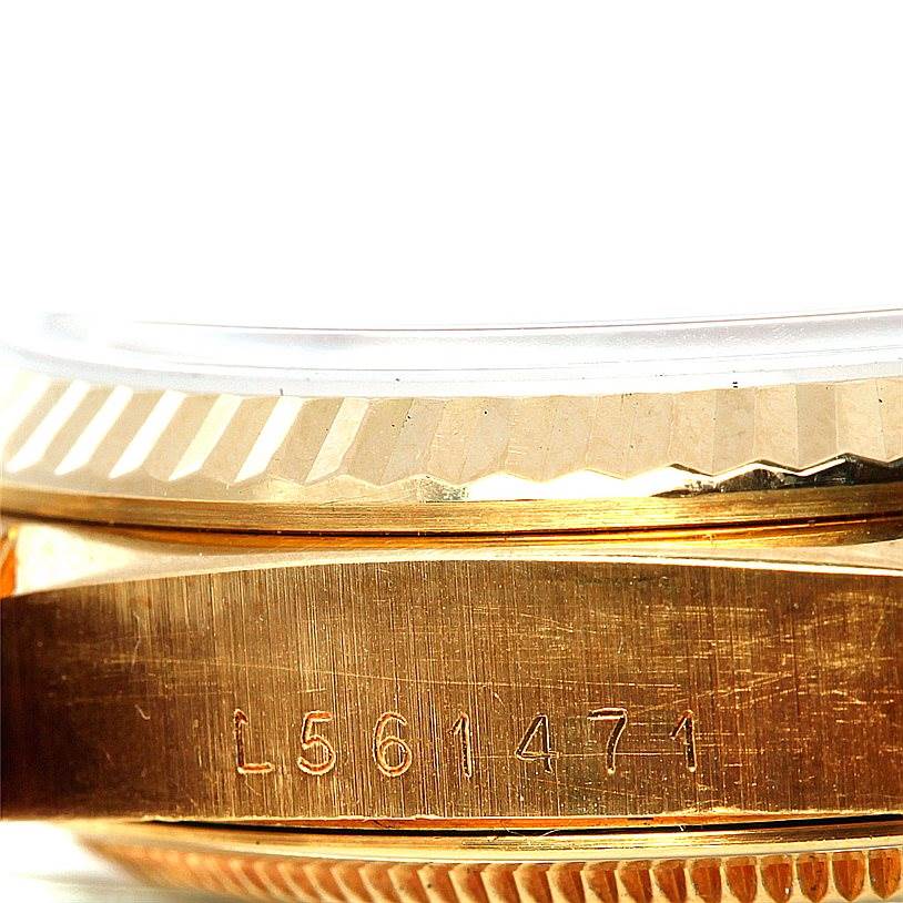 The image shows a close-up of the side of a Rolex President 18238 Men
s Yellow Gold Champagne Dial 18238 Men
s Yellow Gold Champagne Dial model watch, emphasizing its serial number and fluted bezel.