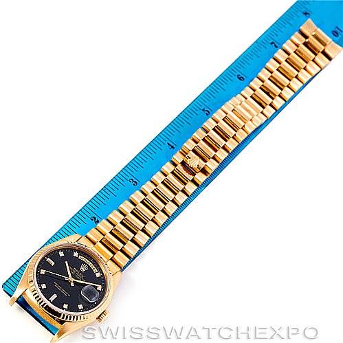 This image shows a Rolex President 18238 Men's Yellow Gold Black Dial 18238 Men's Yellow Gold Black Dial model watch laid flat alongside a blue ruler, displaying the dial, bezel, and bracelet.