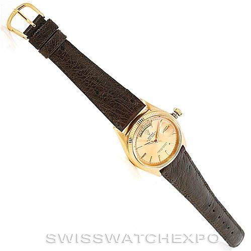 The image shows a top-down view of a Rolex President 1803 Men
s Yellow Gold Champagne Dial 1803 Men
s Yellow Gold Champagne Dial model watch with a brown leather strap and gold case.