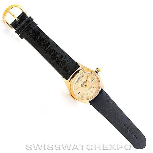 The image shows a Rolex President 18038 Men
s Yellow Gold Champagne Dial 18038 Men
s Yellow Gold Champagne Dial model watch from above, featuring its face and black leather strap with a gold buckle.