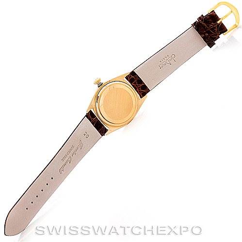 The image shows the backside of a Rolex President 18078 Men
s Yellow Gold Champagne Dial 18078 Men
s Yellow Gold Champagne Dial model watch, highlighting the case back and the leather strap fully extended.