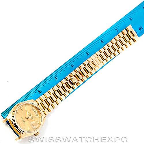 The image shows a Rolex President 18038 Men
s Yellow Gold Champagne Dial 18038 Men
s Yellow Gold Champagne Dial model watch laid flat next to a blue ruler, highlighting the dial and full bracelet.
