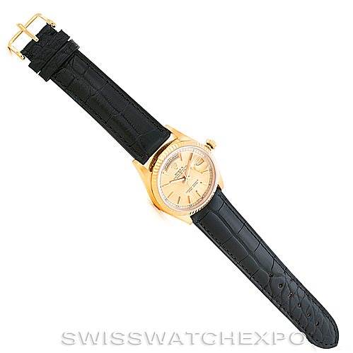 The image shows a Rolex President 18238 Men
s Yellow Gold Champagne Dial 18238 Men
s Yellow Gold Champagne Dial model watch with a black leather strap viewed from above.