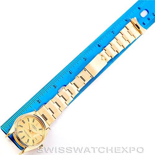 The image shows a Rolex President 15037 Men
s Yellow Gold Champagne Dial 15037 Men
s Yellow Gold Champagne Dial model watch fully extended next to a blue ruler, displaying the watch
s face and entire bracelet.