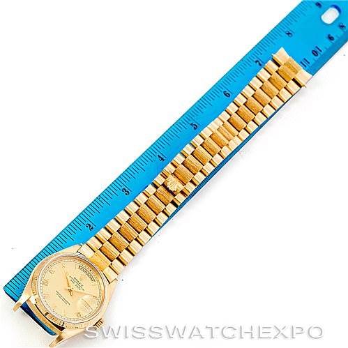 The image shows a Rolex President 18078 Men
s Yellow Gold Champagne Dial 18078 Men
s Yellow Gold Champagne Dial model watch laying flat next to a blue ruler, displaying the watch face and full bracelet.