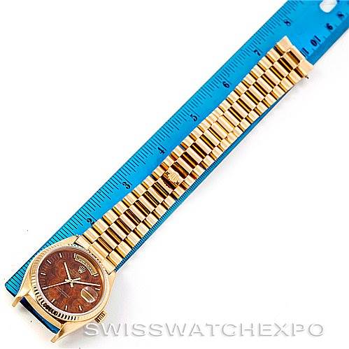 The image shows a top-down view of a Rolex President 18038 Men's Yellow Gold Brown Dial 18038 Men's Yellow Gold Brown Dial model watch with a brown dial and gold bracelet, next to a blue ruler.