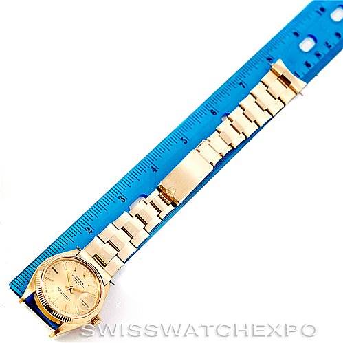 The image shows a Rolex President 1503 Men
s Yellow Gold Champagne Dial 1503 Men
s Yellow Gold Champagne Dial model watch laid flat, with its face and bracelet fully extended next to a blue ruler.