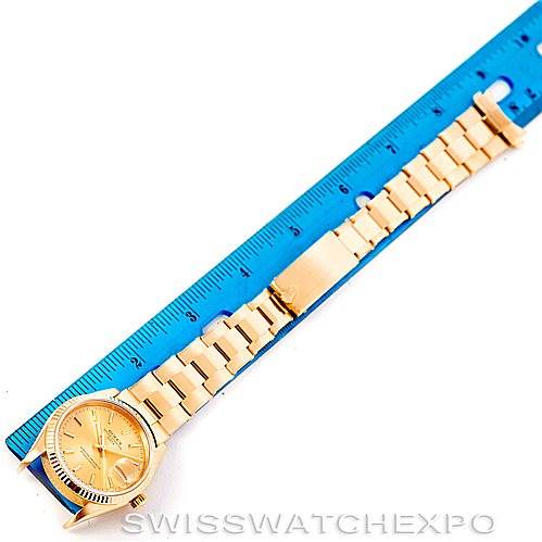 The image shows a Rolex President 15238 Men
s Yellow Gold Champagne Dial 15238 Men
s Yellow Gold Champagne Dial model watch, angled flat next to a blue ruler, highlighting the bracelet and face.