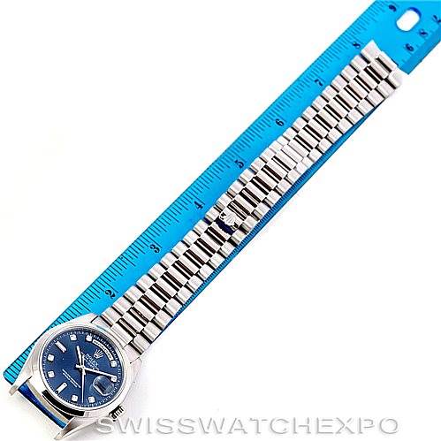 The image shows a Rolex President 18206 Men's Platinum Blue Dial 18206 Men's Platinum Blue Dial model watch laid flat next to a blue ruler, displaying its face and entire bracelet.