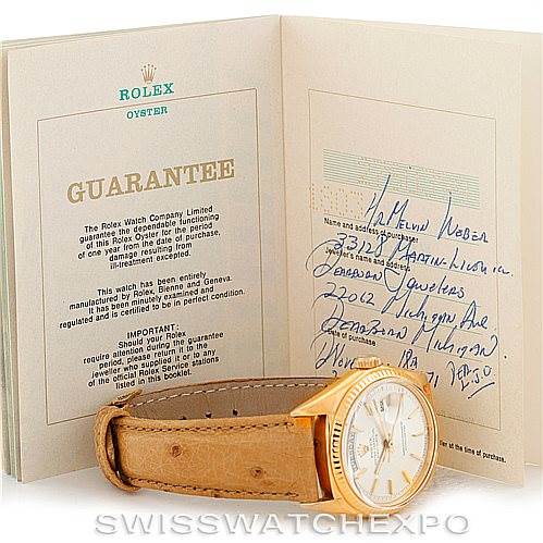 The image shows a Rolex President 1803 Men
s Yellow Gold Silver Dial 1803 Men
s Yellow Gold Silver Dial model watch placed in front of its guarantee paperwork, angled to display the watch face and strap.