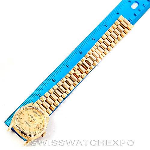 The image shows a Rolex President 1803 Men
s Yellow Gold Champagne Dial 1803 Men
s Yellow Gold Champagne Dial watch in gold, laid flat beside a blue ruler for scale, highlighting its bracelet and watch face.