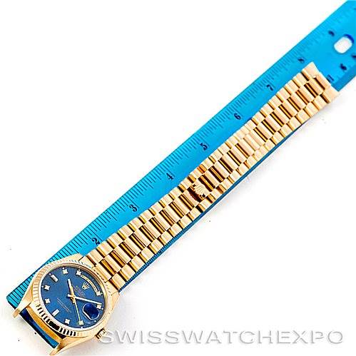 This image shows a top-down view of a Rolex President 18238 Men's Yellow Gold Blue Dial 18238 Men's Yellow Gold Blue Dial model watch, displaying its blue dial and gold bracelet beside a blue ruler for scale.