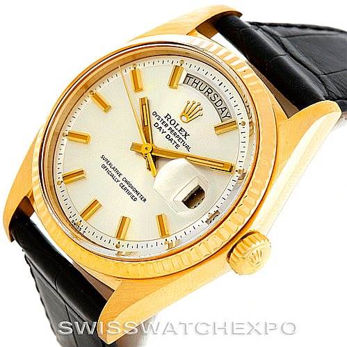 This image shows a Rolex President 1803 Men
s Yellow Gold Silver Dial 1803 Men
s Yellow Gold Silver Dial model watch at an angled close-up, highlighting the dial, crown, bezel, and part of the leather strap.