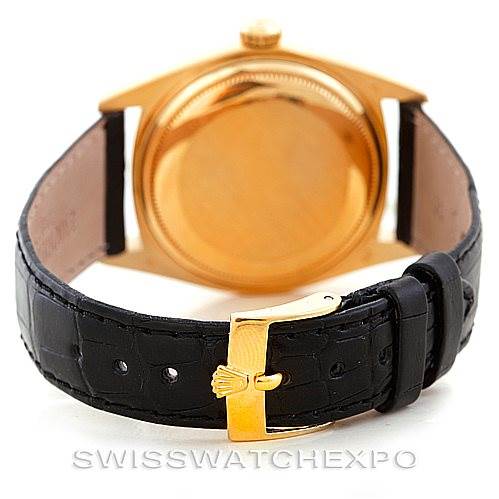 The image shows the back and clasp of a Rolex President 1803 Men
s Yellow Gold Silver Dial 1803 Men
s Yellow Gold Silver Dial model with a gold case and black leather strap viewed from the rear.