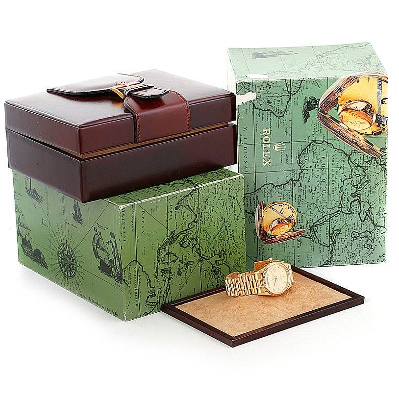 The image displays a Rolex President 18238 Men
s Yellow Gold Champagne Dial 18238 Men
s Yellow Gold Champagne Dial watch with its green map-themed boxes and a leather case from an angled overview.